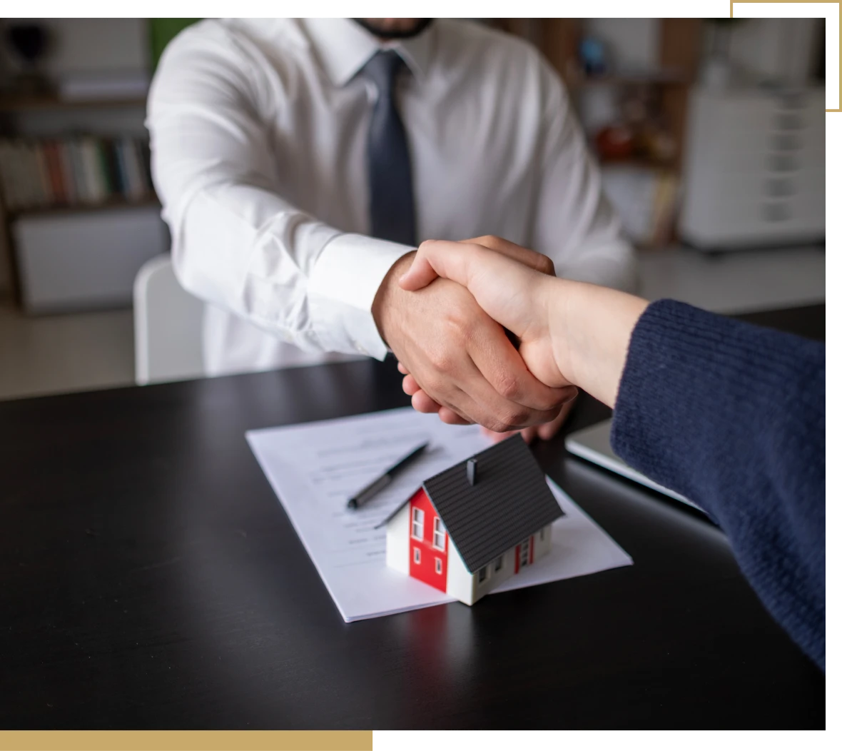 Agreement finalized with handshake in office.